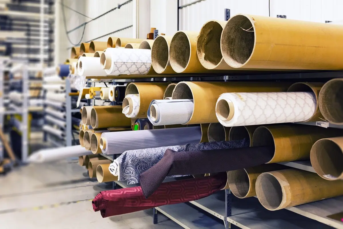 Rolls of fabric stacked on warehouse racking