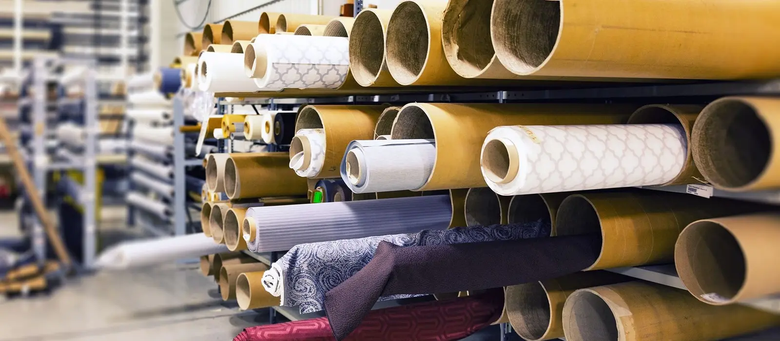 Rolls of fabric stacked on warehouse racking