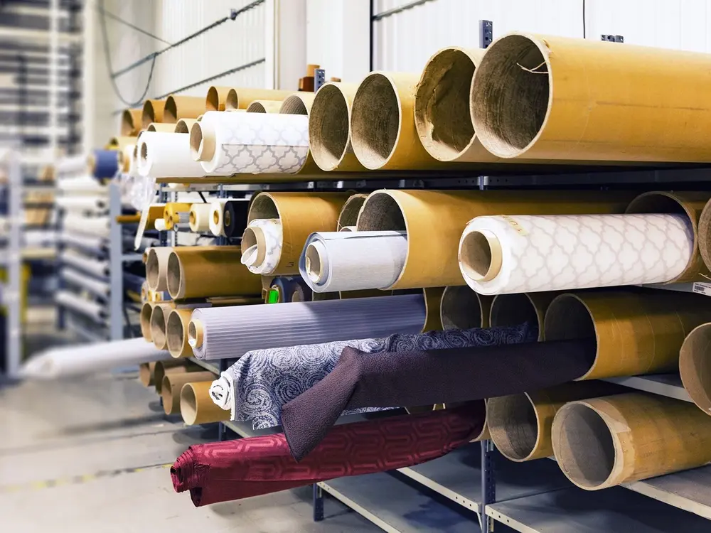 Rolls of fabric stacked on warehouse racking