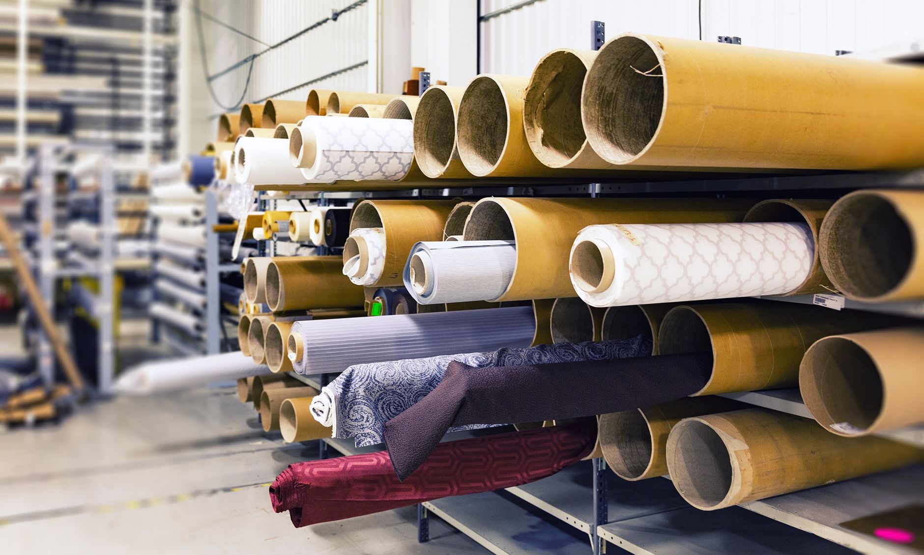 Rolls of fabric stacked on warehouse racking